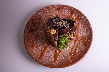 Fındıklı krep çikolatalı pasta, beyaz arka planda izole edilmiş kahverengi kil tabakta ballı kek. Yüksek kalite fotoğraf