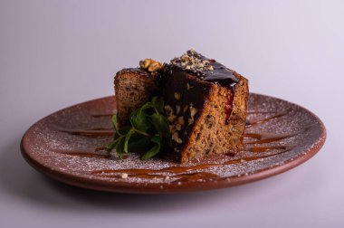 Fındıklı krep çikolatalı pasta, beyaz arka planda izole edilmiş kahverengi kil tabakta ballı kek. Yüksek kalite fotoğraf