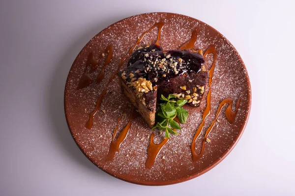 Fındıklı krep çikolatalı pasta, beyaz arka planda izole edilmiş kahverengi kil tabakta ballı kek. Yüksek kalite fotoğraf