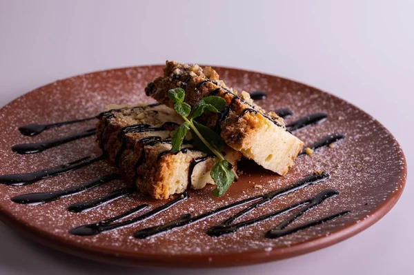 Beyaz arka planda kahverengi kil tabakta yaban mersini soslu bir parça cheesecake. Yakın çekim görüntüsü. Çay için tatlı konsepti