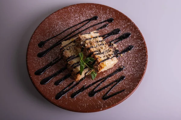 Ein Stück Käsekuchen Mit Blaubeer Karamellsoße Auf Einem Braunen Tonteller — Stockfoto