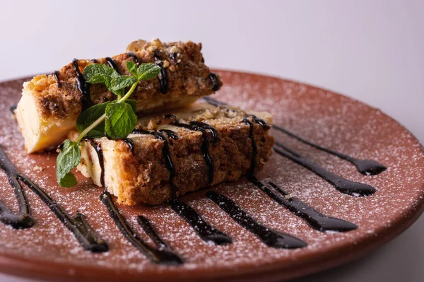 Beyaz arka planda kahverengi kil tabakta yaban mersini soslu bir parça cheesecake. Yakın çekim görüntüsü. Çay için tatlı konsepti