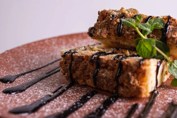 Beyaz arka planda kahverengi kil tabakta yaban mersini soslu bir parça cheesecake. Yakın çekim görüntüsü. Çay için tatlı konsepti