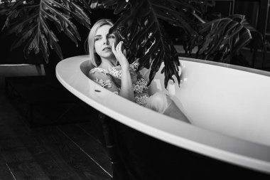 Siyah beyaz klasik fotoğraf. Kadınlar açık bir banyoda tropik çiçeklerle, organik cilt bakımıyla, lüks spa oteliyle, yaşam tarzı fotoğraflarıyla rahatlıyor. Seçici odak