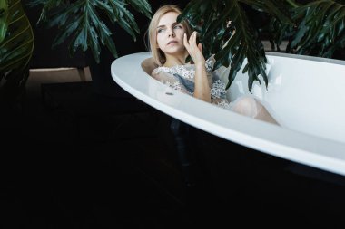 Kadınlar açık bir banyoda tropik çiçeklerle, organik cilt bakımıyla, lüks spa oteliyle, yaşam tarzı fotoğraflarıyla rahatlıyor. Seçici odak