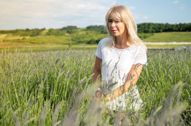 beautiful, young beautiful girl in a light white dress on a lavender field, summer