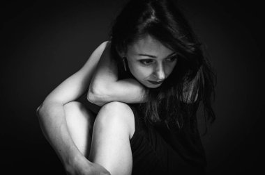Genç ve güzel bir kızın duygusal portresi yerde oturuyor, düşünceli, düşünceli, depresyonlu, karanlık geçmişi olan, sade bir kız.