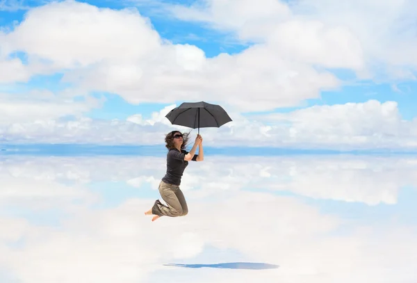Junge Frau springt mit Regenschirm — Stockfoto