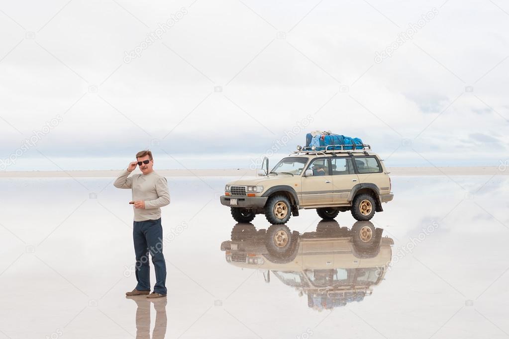 Man and car on lake Salar de Uyuni, Bolivia