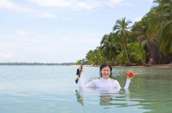 Donna che tiene la stella marina e maschera subacquea — Foto Stock
