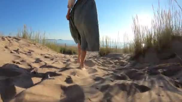 Närbild av smala ben av en ung kvinna som går längs en strand — Stockvideo