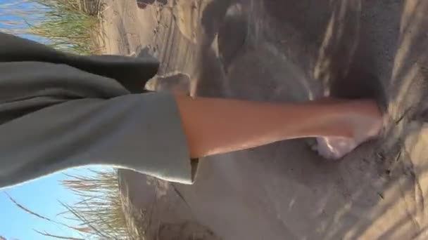 Close-up af en ung kvindes slanke ben, der går langs en strand – Stock-video