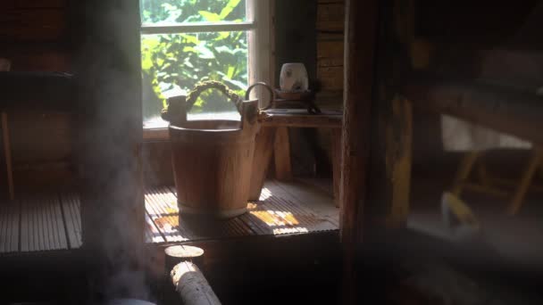 Wnętrze tradycyjnej sauny fińskiej z drewnianymi akcesoriami i parą — Wideo stockowe