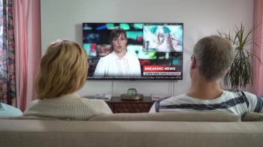 Aile Çifti TV Haberleri İzliyor Kanepede Birlikte Oturuyorlar.