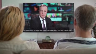 Aile Çifti TV Haberleri İzliyor Kanepede Birlikte Oturuyorlar.