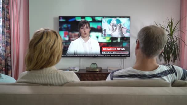 Familie paar Kijken TV Nieuws Zittend op de bank in de woonkamer samen. — Stockvideo