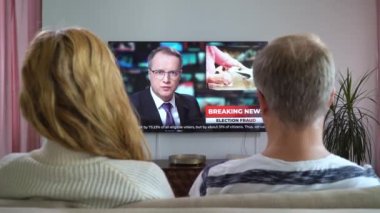 Aile Çifti TV Haberleri İzliyor Kanepede Birlikte Oturuyorlar.
