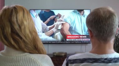 Aile Çifti TV Haberleri İzliyor Kanepede Birlikte Oturuyorlar.