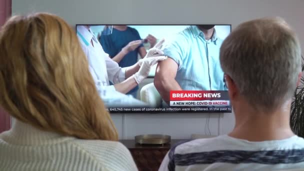 Familie paar Kijken TV Nieuws Zittend op de bank in de woonkamer samen. — Stockvideo