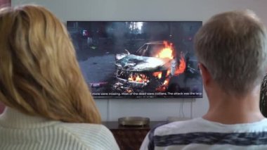 Aile Çifti TV Haberleri İzliyor Kanepede Birlikte Oturuyorlar.