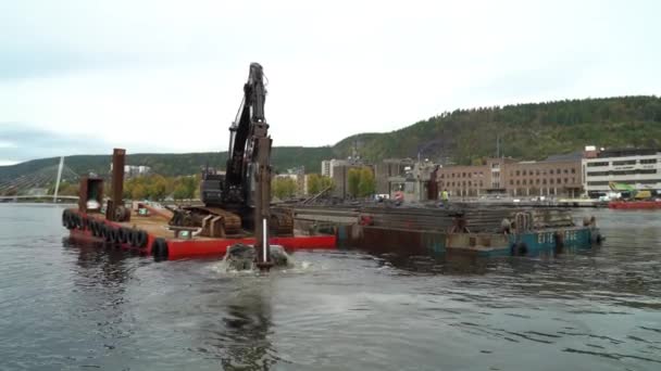 Una gran excavadora en una plataforma flotante que limpia el fondo del río — Vídeo de stock