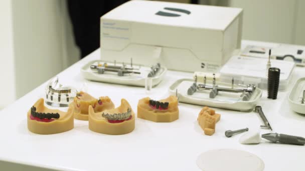 Modell des menschlichen Kiefers mit Proben von Zahnkronen auf dem Stativ. — Stockvideo