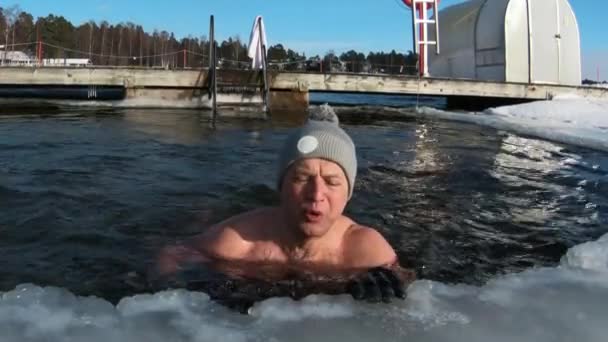Kışın buz çukurunda yüzen bir adam.. — Stok video