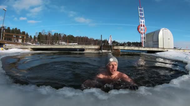 Ένας άντρας κολυμπάει σε μια παγωμένη τρύπα το χειμώνα.. — Αρχείο Βίντεο