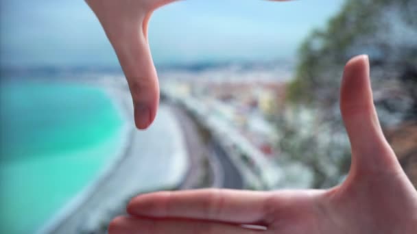 Γυναίκα κάνει ένα πλαίσιο με τα δάχτυλα πάνω στην παραλία στην την Κυανή Ακτή Νίκαια — Αρχείο Βίντεο