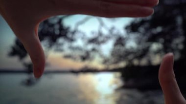 Parmak Çerçevesi. Finlandiya 'da yaz ortasında gece gün batımı