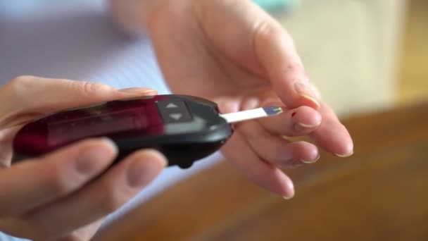 Diabetespatient som mäter blodglukosnivån med en glukometer — Stockvideo