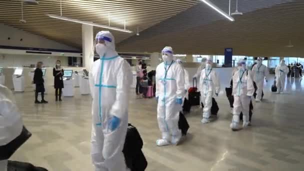 Skupina asijských turistů v ochranných jednorázových antivirových oblecích a maskách na letišti — Stock video