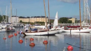 HELSINKI, FINLAND - 13 Ağustos 2022: Geleneksel ahşap yelkenliler Suomenlinna adasındaki marinadan Viaporin Tuoppi Regatta için denize açılmaya hazırlanıyorlar