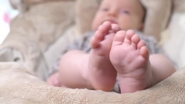 靠近新生儿的脚 可爱的小宝宝躺在床上 孩子在荡秋千里放松 穿着紧身衣的可爱新生儿 — 图库视频影像