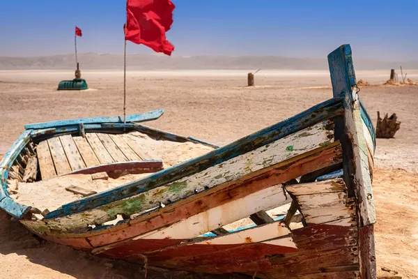 Um velho barco está sozinho no meio de um deserto de sal. — Fotografia de Stock