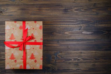 Tahta arka planda Noel hediyesi kutusu. Xmas ve Mutlu Yıllar teması. Düz yerde, üst tarafta. Boşluğu Kopyala