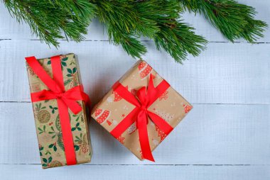 Noel ağacı dallı beyaz ahşap arka planda Noel hediyesi kutuları. Xmas ve Mutlu Yıllar teması. Düz yerde, üst tarafta. Boşluğu kopyala