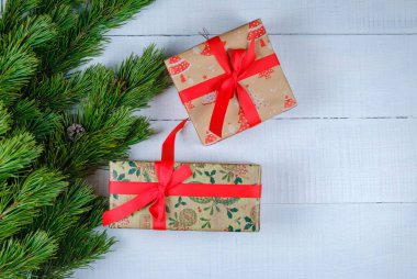 Noel ağacı dallı beyaz ahşap arka planda Noel hediyesi kutuları. Xmas ve Mutlu Yıllar teması. Düz yerde, üst tarafta. Boşluğu kopyala