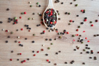 Ahşap arka planda farklı türde biberli ahşap kaşık. Üst Manzara. Boşluğu kopyala.