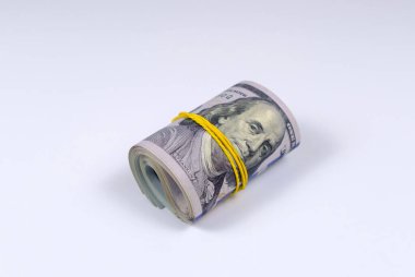 Para rulosu, beyaz arka planda lastik bant ile sıkılaştırılmış. Yuvarlanan Amerikan doları