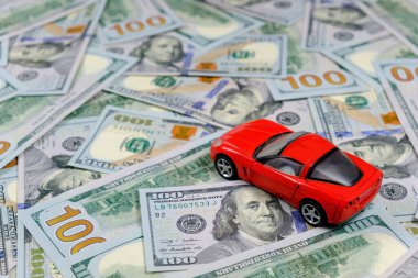 Küçük oyuncak araba ve para. Kredi ve finans kavramları