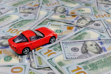 Küçük oyuncak araba ve para. Kredi ve finans kavramları