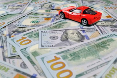 Küçük oyuncak araba ve para. Kredi ve finans kavramları