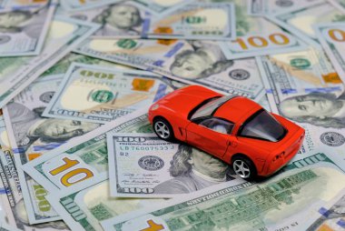 Küçük oyuncak araba ve para. Kredi ve finans kavramları