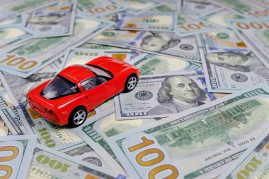 Küçük oyuncak araba ve para. Kredi ve finans kavramları