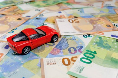 Küçük oyuncak araba ve para. Kredi ve finans kavramları