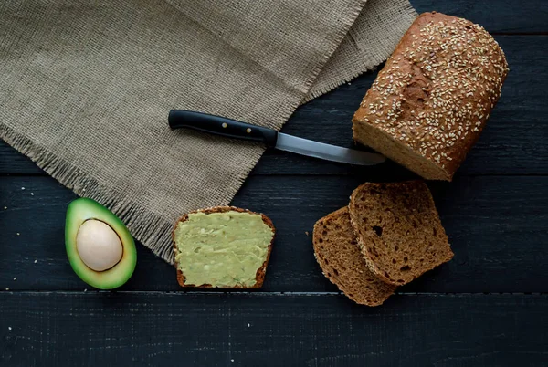 Koyu ahşap masada avokado püresi ile tost. Sağlıklı yiyecekler ve vejetaryen diyet kavramları