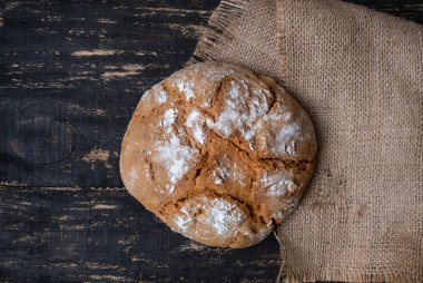 Arka planda çuval bezi olan taze ev yapımı ekmek. Üst Manzara. Kırsal biçim