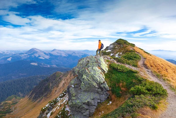 Tourist in mountains with blue sky and clouds on background