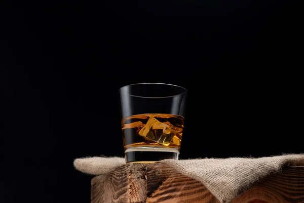 Glass Whiskey Ice Cubes Wooden Table Burlap Napkin Black Background — Foto Stock